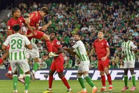 Kike Salas leaps highest to head home Sevilla's goal in the derby draw with Real Betis. (EPA PHOTO)
